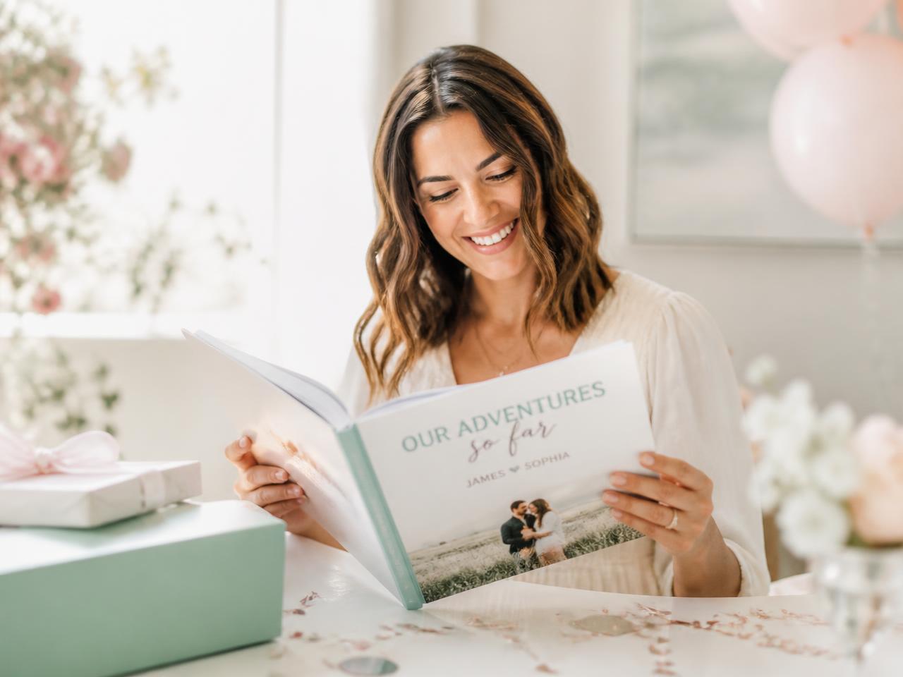 A woman smiling while opening a personalized keepsake photo book